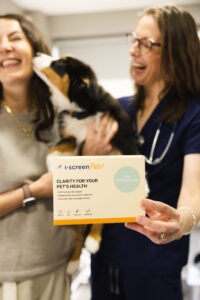 Dr. Nicole Rous holding an i-screenPets gut microbiome testing kit used to assess canine gut health and the gut brain axis.